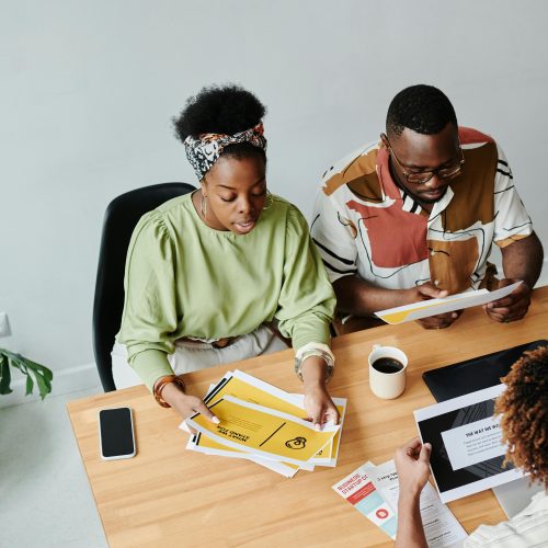 Diverse team engaged in a collaborative meeting reviewing documents and ideas.